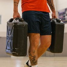 man carrying heavy containers