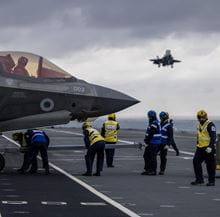 Aircraft and personnel on deck of an aircraft carrier