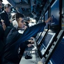 Submariner with a headset on inside a submarine