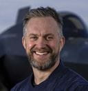 Captain Will Blackett (Captain PWLS) in front of an F-35 on the flight deck of HMS Prince of Wales
