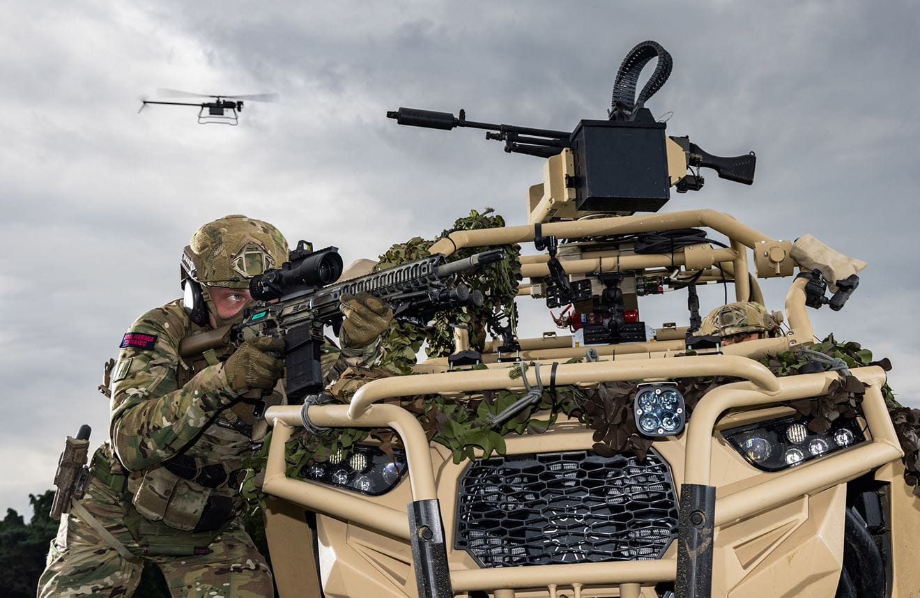Royal-Navy-Royal-Marines-Equipment-05-State-Of-The-Art-Weapons Royal Marine of 40 Commando taking aim behind a Polaris with drone in the background