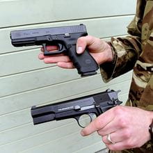 Royal-Navy-Equipment-Commando-Weaponry-03-Glock Close up of hands holding two Glock 17 pistols