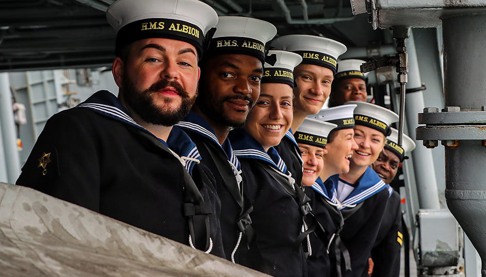 Royal-Navy-Families-03-Benefits Sailors of HMS Albion standing in a row smiling at camera