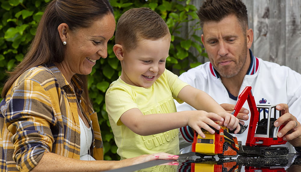 Royal-Navy-Families-04-Accommodation Mother and father with son playing with a toy digger