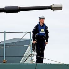 A sailor stands on deck