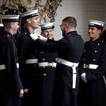 Royal-Navy-Our-People-Leadership-05-living.jpg Royal Navy sailors smile while one helps another with uniform