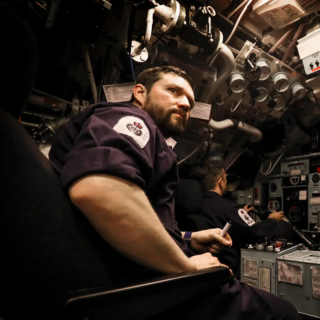 Man on a submarine looks to the side