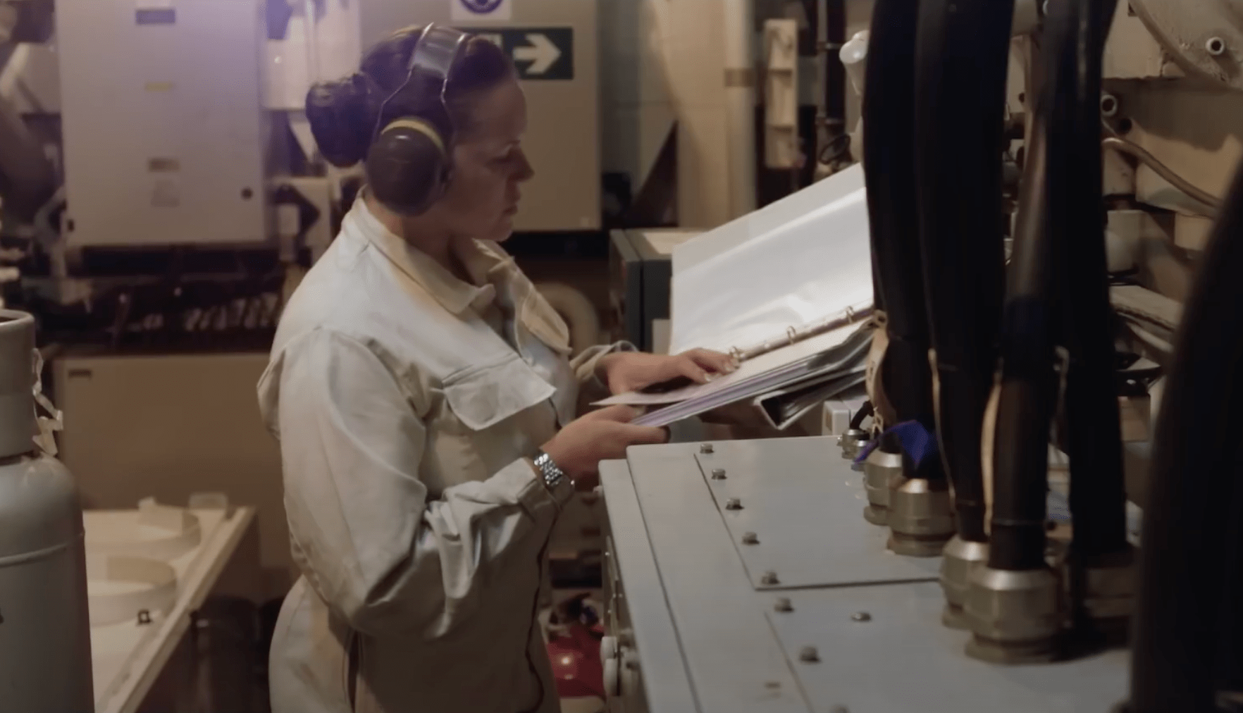 Beth, a Marine Engineering officer submariner reading some files next to some euiptment