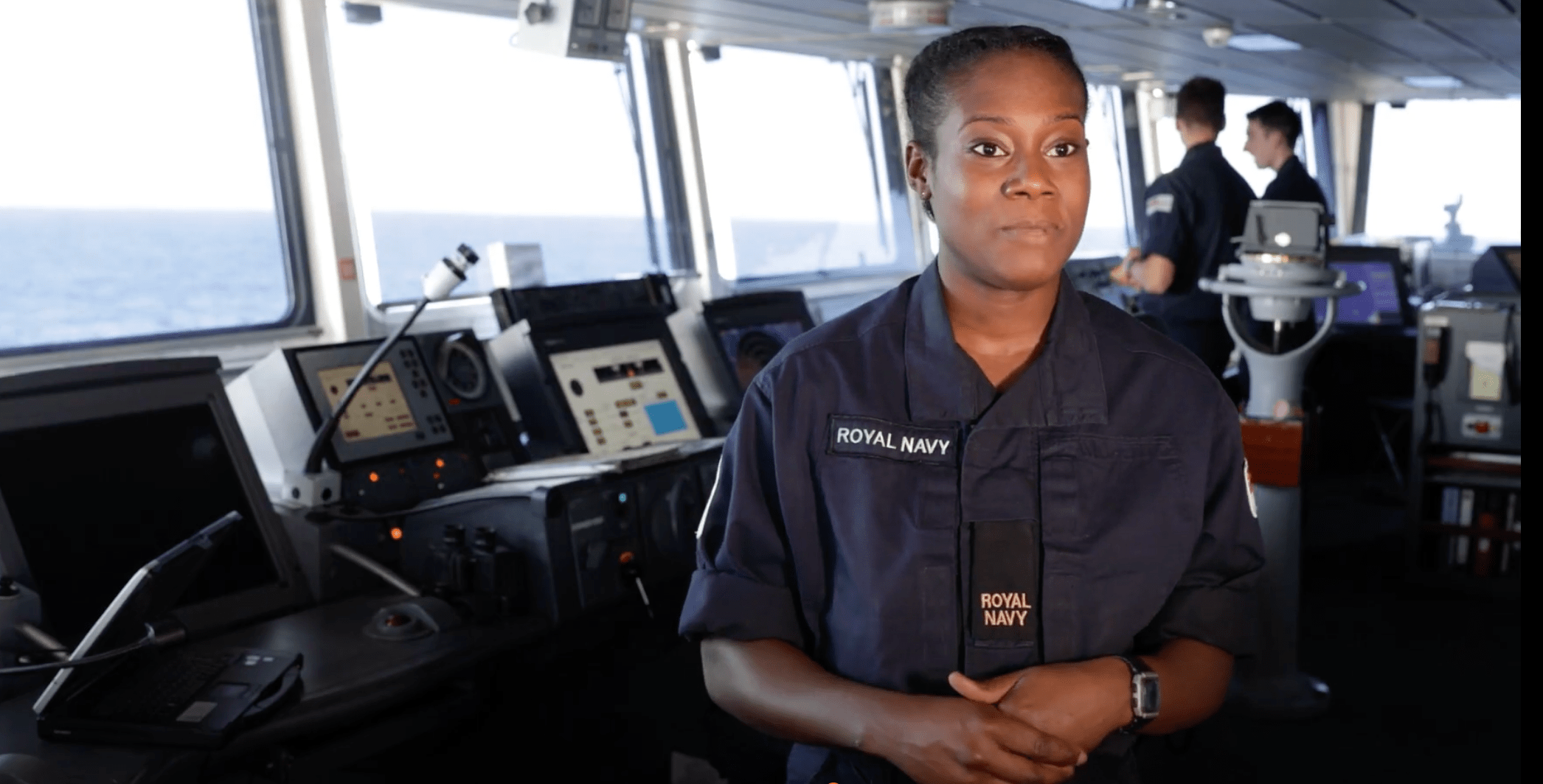 A Royal Navy Writer talking to the camera in the ships bridge