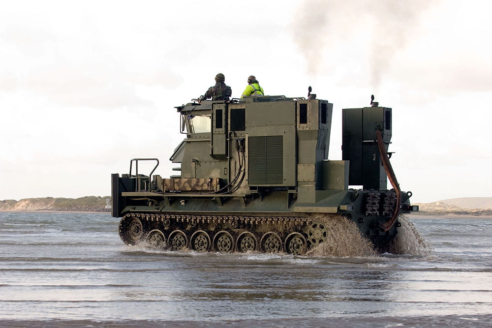 Royal-Navy-Equipment-Commando-By-Land-06-Beach-Recovery-Vehicle Side-on view a beach recovery vehicle driving through shallow water