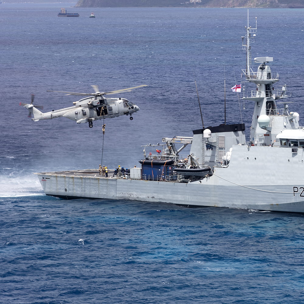 Merlin helicopter drops humanitarian aid supplies onto HMS Medway