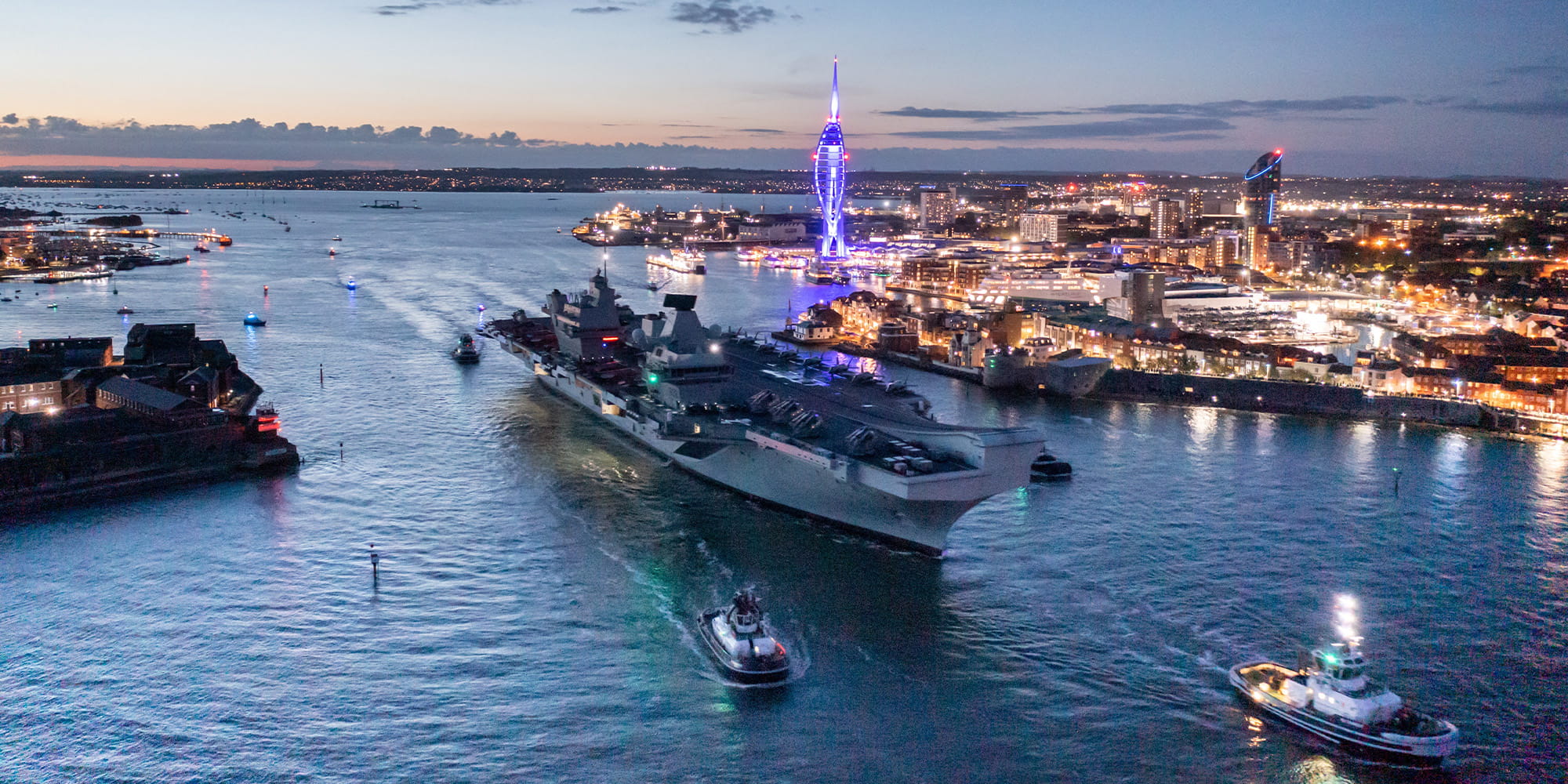 Queen Elizabeth carrier approaching harbour at dusk