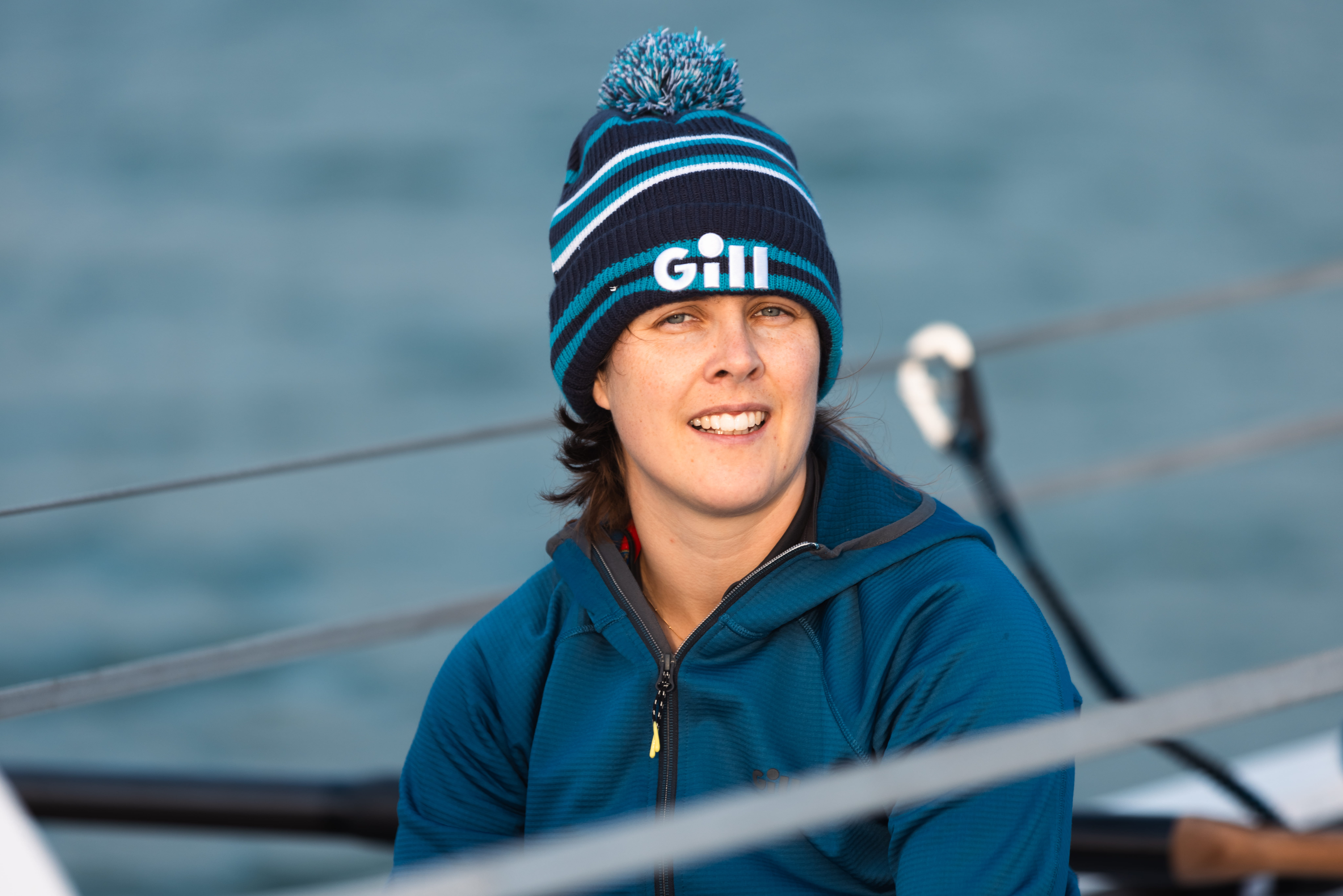 Izzy smiling while waring a blue cap and top