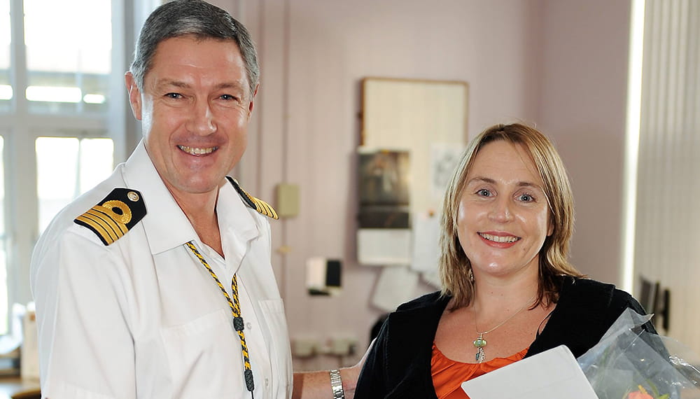 Lady being presented with flowers by senior Naval Officer