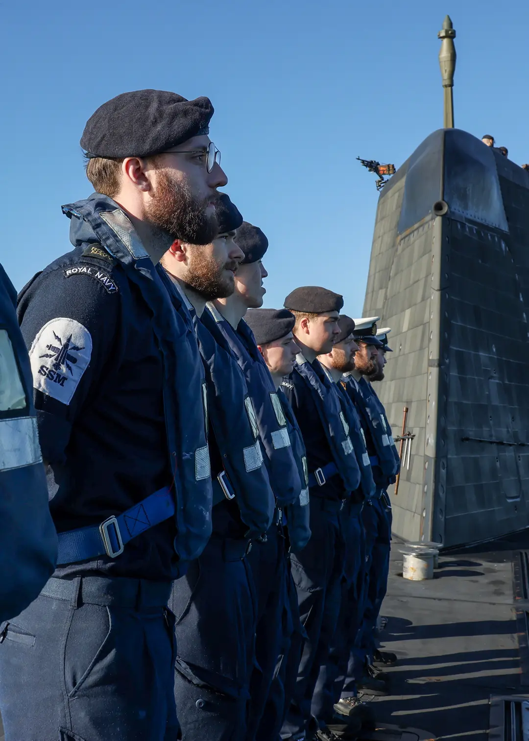 Men on a submarine look to the right